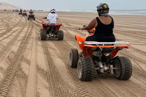 Riders on quad bikes navigating sand dune trails in the Takkat countryside outside Agadir